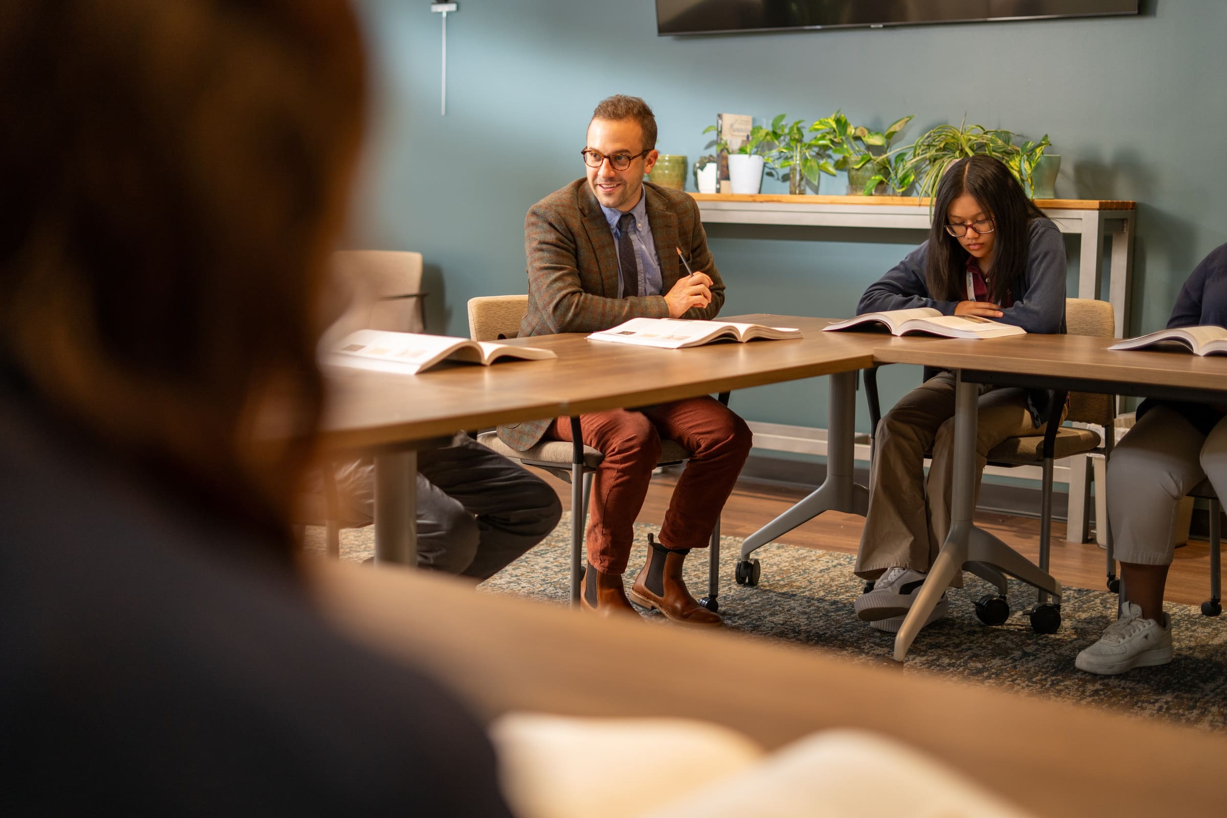 A ClassicalU presenter leading a seminar discussion around a table with students